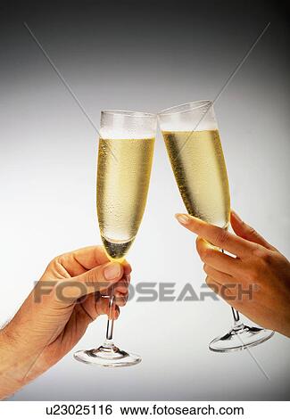 Man And Woman'S Hand Holding Glasses Of Champagne Making A Toast View Large Photo Image Stock Photograph - Man And Woman'S Hand Holding Glasses Of Champagne Making A Toast. Fotosearch