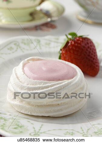 Stock Photography - Meringue nest filled with strawberry mousse petites fours. Fotosearch