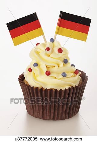 Stock Photography - One Cupcake With Buttercream Topping Decorated With Two German Flags, Brown Cake Case, On White. Fotosearch