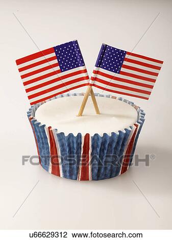 Stock Image - One White Iced Cupcake Decorated With Two Small American Flags, On White Background. Fotosearch