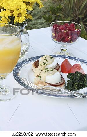 Stock Image - Plate Of Eggs Benedict Served On Outdoor Table. Fotosearch