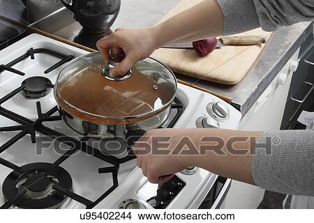 Putting a lid on a saucepan of simmering chicken rogan josh View Large Photo Image Picture - Putting a lid on a saucepan of simmering chicken rogan josh. Fotosearch