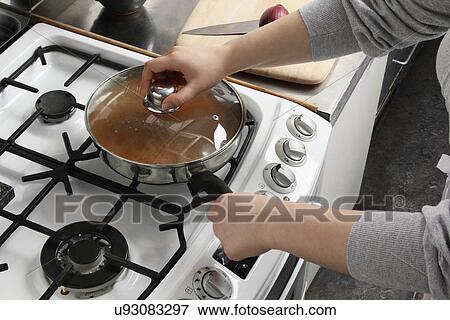 Putting a lid on a saucepan of simmering chicken rogan josh View Large Photo Image Stock Photo - Putting a lid on a saucepan of simmering chicken rogan josh. Fotosearch