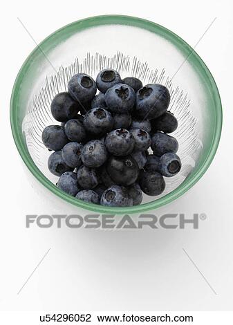 Stock Image - Ripe blueberries in a glass bowl on a white background. Fotosearch