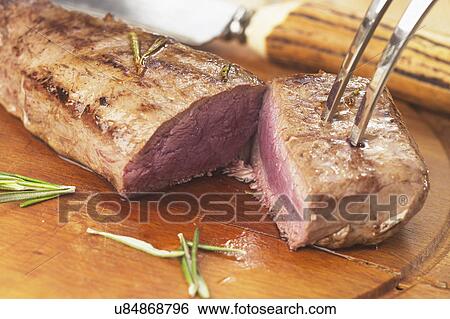 Stock Photograph - Roast Loin Of Venison Being Carved. Fotosearch
