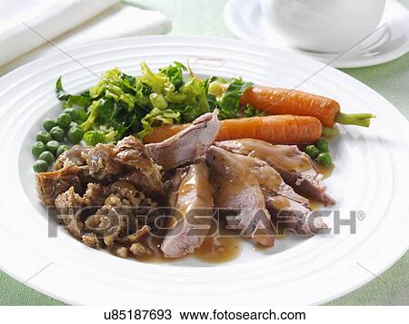 Stock Image - Roast turkey thigh with stuffing carrots cabbage peas and gravy. Fotosearch