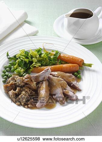 Stock Photo - Roast turkey thigh with stuffing carrots cabbage peas and gravy. Fotosearch