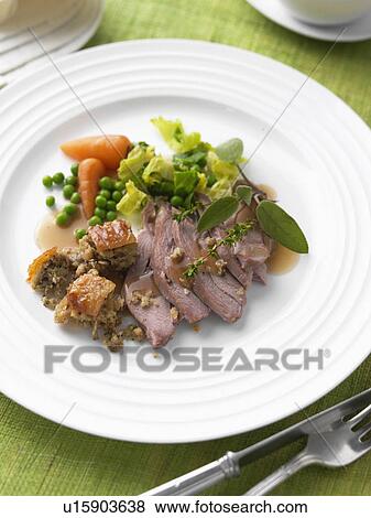 Stock Photo - Roast turkey thigh with stuffing carrots cabbage peas and gravy sage thyme. Fotosearch