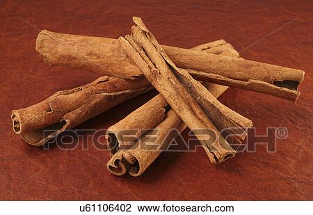 Stock Image - Rolls Of Caribbean Cinnamon Bark Sticks On Brown Tabletop. Fotosearch