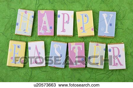 Stock Image - Row Of Wrapped Candy Or Chocolate Bars With Letters Spelling Greeting, Easter, On Green Background. Fotosearch