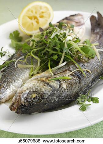 Stock Photo - Sea bass cooked in foil with ginger and spring onions. Fotosearch