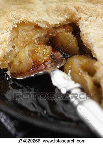 Stock Photograph - Serving an apple pie cooked in pan. Fotosearch
