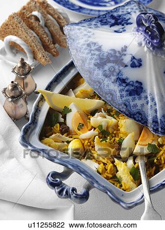 Stock Image - Serving dish of kedgeree with toast. Fotosearch