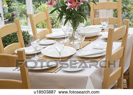 Set Wooden Dining Table With White Tablecloth, Plates, Glassware And Fresh Flowers In Sunny Daytime Room View Large Photo Image Stock Photo - Set Wooden Dining Table With White Tablecloth, Plates, Glassware And Fresh Flowers In Sunny Daytime Room. Fotosearch
