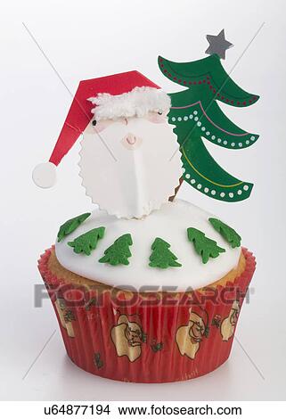 Single White Iced Sponge Cupcake In Paper Case Topped With Father Christmas, Christmas Tree And Little Trees Around Edge Of Cake, White Background View Large Photo Image Picture - Single White Iced Sponge Cupcake In Paper Case Topped With Father Christmas, Christmas Tree And Little Trees Around Edge Of Cake, White Background. Fotosearch