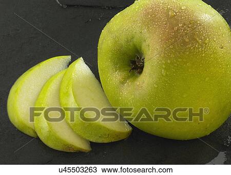 Stock Image - Sliced Apple On Slate Background. Fotosearch