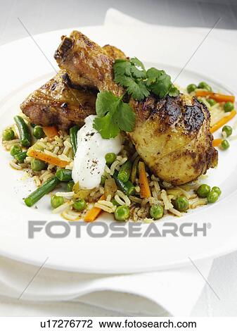Stock Image - Spiced chicken legs with basmati rice and steamed vegetables. Fotosearch
