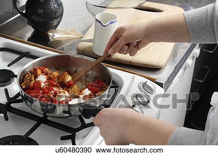 Stock Image - Stirring frying chicken. Fotosearch