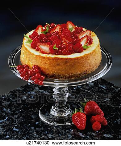 Stock Image - Strawberry And Red Currant Cheesecake On Glass Cake Stand, Black Background. Fotosearch