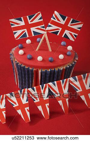 Themed British Celebration Cupcake, Red Iced Sponge Fairy Cake, Topped With White And Blue Sprinkles And Small Union Jack Flags, On Red With Union Jack Bunting View Large Photo Image Stock Image - Themed British Celebration Cupcake, Red Iced Sponge Fairy Cake, Topped With White And Blue Sprinkles And Small Union Jack Flags, On Red With Union Jack Bunting. Fotosearch
