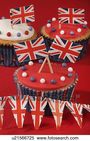 Themed British Celebration Cupcakes, Iced Sponge Fairy Cakes, Topped With Red White And Blue Sprinkles And Small Union Jack Flags, On Red With Union Jack Bunting View Large Photo Image Stock Photography - Themed British Celebration Cupcakes, Iced Sponge Fairy Cakes, Topped With Red White And Blue Sprinkles And Small Union Jack Flags, On Red With Union Jack Bunting. Fotosearch