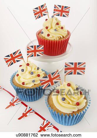 Three Themed British Celebration Cupcakes, Blue And Red Cake Cases Filled With Sponge Cake, Topped With Buttercream Red And Blue Sprinkles And Small Union Jack Flags, On White With Union Jack Bunting View Large Photo Image Stock Image - Three Themed British Celebration Cupcakes, Blue And Red Cake Cases Filled With Sponge Cake, Topped With Buttercream Red And Blue Sprinkles And Small Union Jack Flags, On White With Union Jack Bunting. Fotosearch