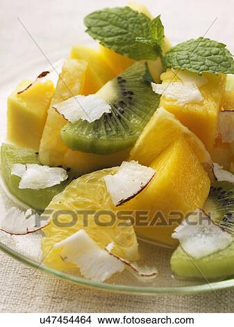 Picture - Tropical fruit salad with kiwi fruit pineapple mango and coconut shavings individual portion. Fotosearch