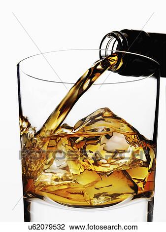 Whisky being poured in to glass with ice View Large Photo Image Stock Image - Whisky being poured in to glass with ice. Fotosearch