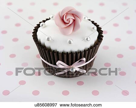 White Iced Cupcake Decorated With White Icing, Pearls And Pink Rosebud, In Brown Cake Case, With Pink Ribbon, White And Pink Polka Dot Tabletop View Large Photo Image Stock Photo - White Iced Cupcake Decorated With White Icing, Pearls And Pink Rosebud, In Brown Cake Case, With Pink Ribbon, White And Pink Polka Dot Tabletop. Fotosearch