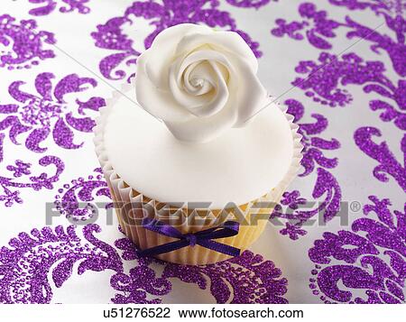 White Iced Cupcake With Single White Rose On Elegant Purple Brocade Patterned Tabletop View Large Photo Image Stock Image - White Iced Cupcake With Single White Rose On Elegant Purple Brocade Patterned Tabletop. Fotosearch
