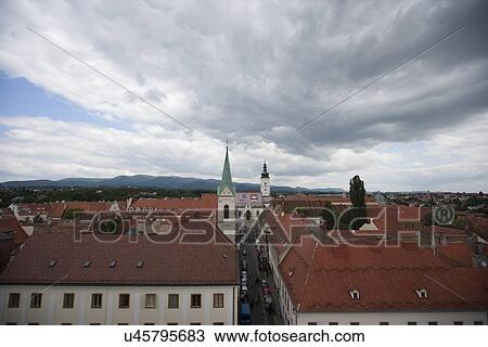 Stock Image - High angle view of churches amidst townscape against cloudy sky, Zagreb, Croatia. Fotosearch