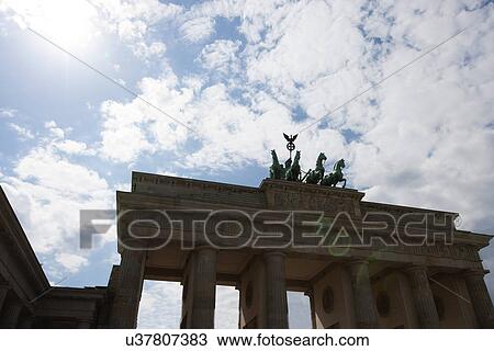 Stock Image - Low angle view of Brandenburg Gate against cloudy sky, Berlin, Germany, Europe. Fotosearch
