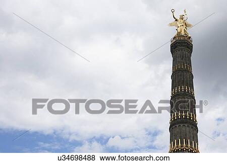 Low angle view of Victory Column against cloudy sky, Berlin, Germany, Europe View Large Photo Image Stock Photo - Low angle view of Victory Column against cloudy sky, Berlin, Germany, Europe. Fotosearch