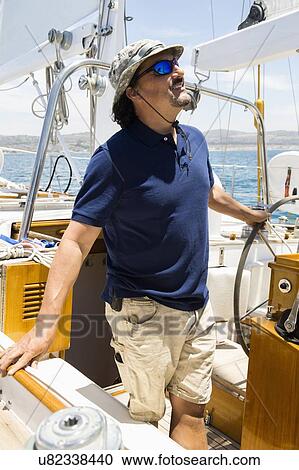 Man steering yacht View Large Photo Image Stock Image - Man steering yacht. Fotosearch