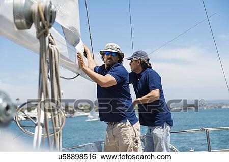 Stock Photograph - Men working on sailing yacht. Fotosearch