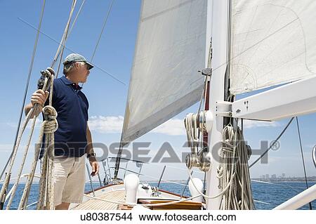 Middle-aged man standing on yacht View Large Photo Image Picture - Middle-aged man standing on yacht. Fotosearch