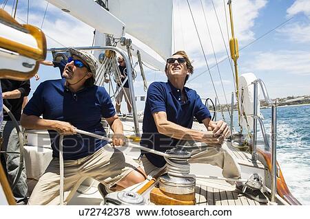 Sailing crew turning crank handle on yacht View Large Photo Image Stock Photo - Sailing crew turning crank handle on yacht. Fotosearch