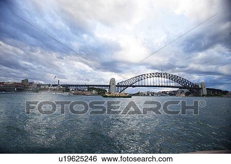 View of Harbor bridge against cloudy sky, Sydney, Australia View Large Photo Image Stock Photograph - View of Harbor bridge against cloudy sky, Sydney, Australia. Fotosearch