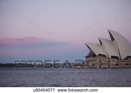Stock Photo - View of Opera house with sea in foreground at dusk, Sydney, Australia. Fotosearch