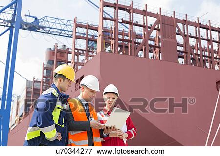 Workers discussing in shipping yard View Large Photo Image Stock Photo - Workers discussing in shipping yard. Fotosearch