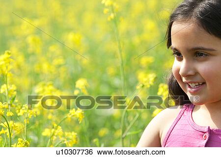 Stock Photograph - A young girl in a field . Fotosearch