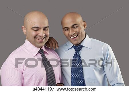 Bald executives looking at a mobile phone View Large Photo Image Stock Photo - Bald executives looking at a mobile phone . Fotosearch