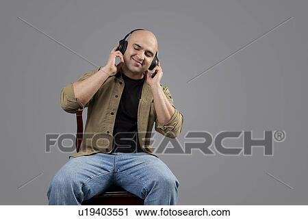 Stock Image - Bald man listening to music . Fotosearch