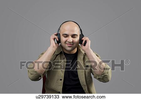 Bald man listening to music View Large Photo Image Stock Image - Bald man listening to music . Fotosearch