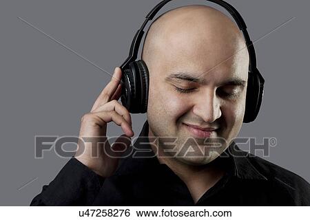 Bald man listening to music View Large Photo Image Stock Photograph - Bald man listening to music . Fotosearch