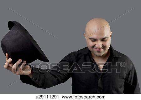 Bald man taking off his hat View Large Photo Image Stock Image - Bald man taking off his hat . Fotosearch