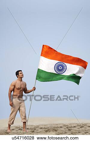 Stock Photo - Bare chested man holding the Indian flag . Fotosearch
