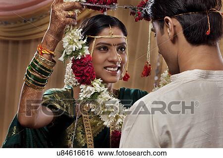 Beautiful bride exchanging garlands with her groom View Large Photo Image Stock Photograph - Beautiful bride exchanging garlands with her groom . Fotosearch