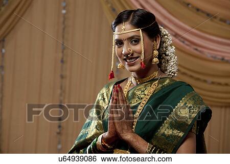 Stock Photograph - Beautiful Indian bride praying with hands clasped . Fotosearch