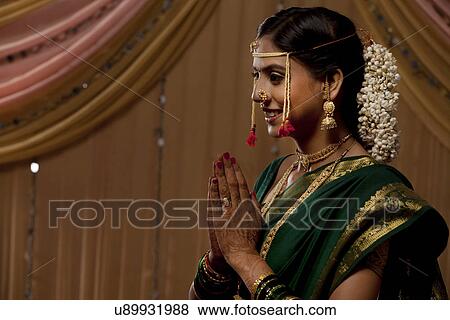 Beautiful Indian bride smiling with hands clasped View Large Photo Image Stock Photo - Beautiful Indian bride smiling with hands clasped . Fotosearch